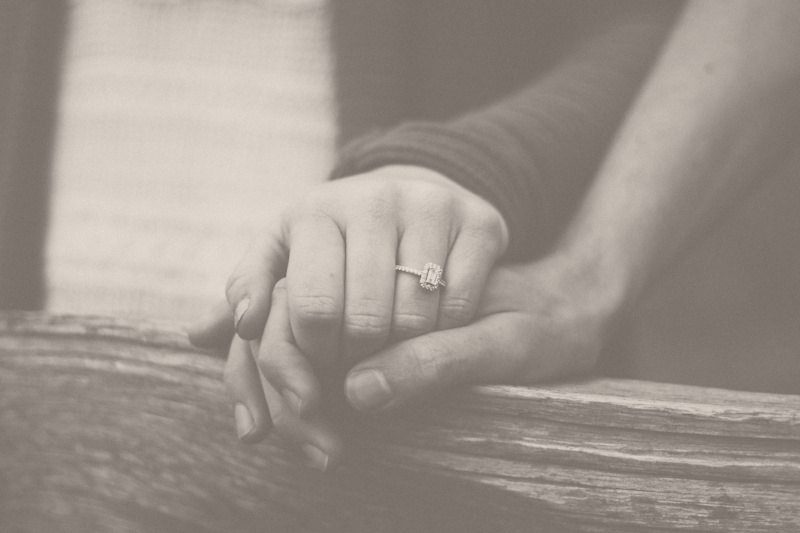 A couple holding hands, resting on weathered wood
